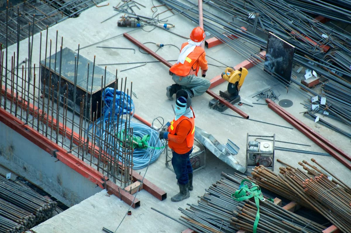 Artisans du bois sur chantier — charpentier marquant une pièce avant coupe